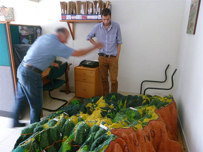 The author (right) studies the scale model used to inform local people about La Colosa’s potential impact (© Doug Specht)